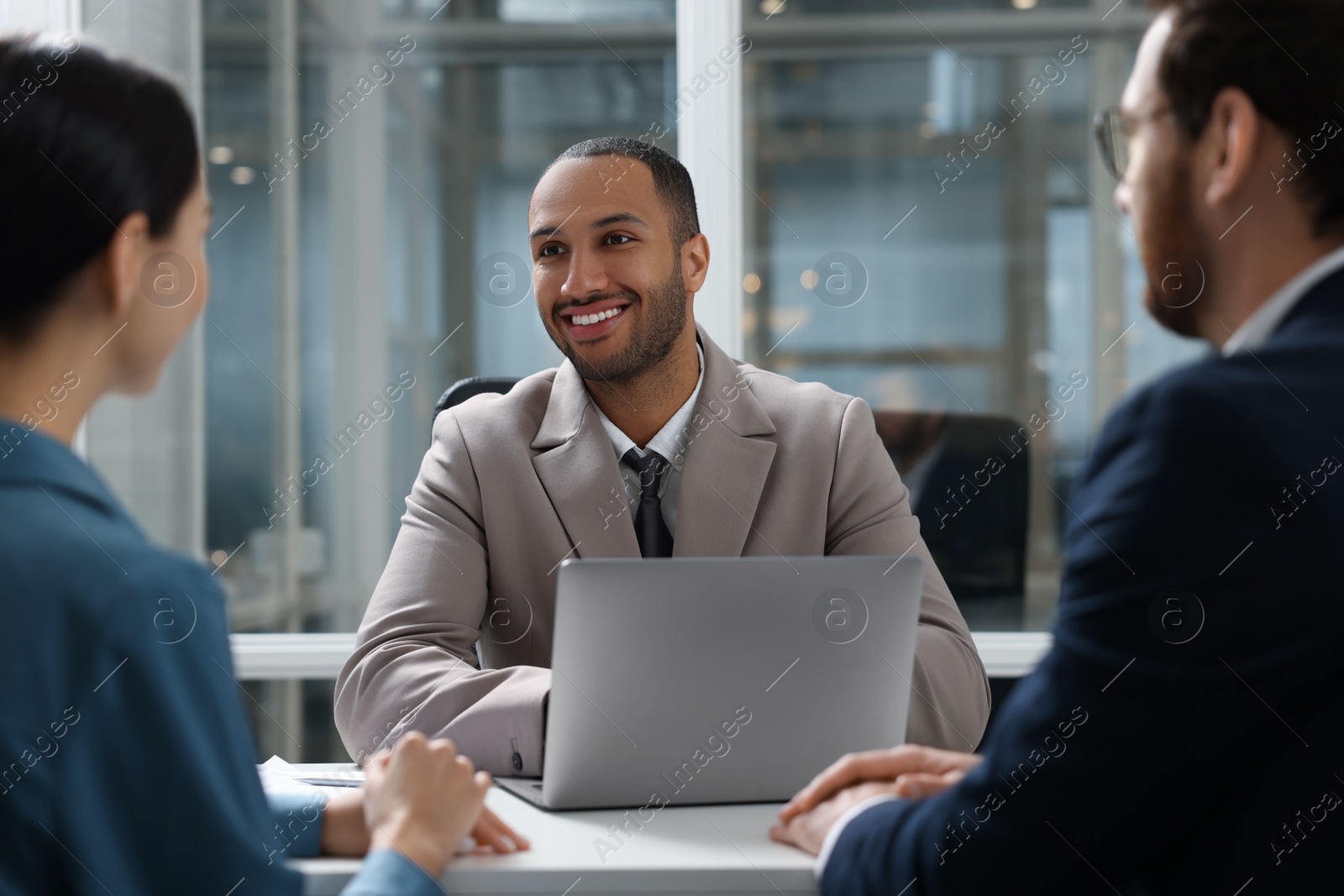 Photo of Lawyer working with clients at table in office