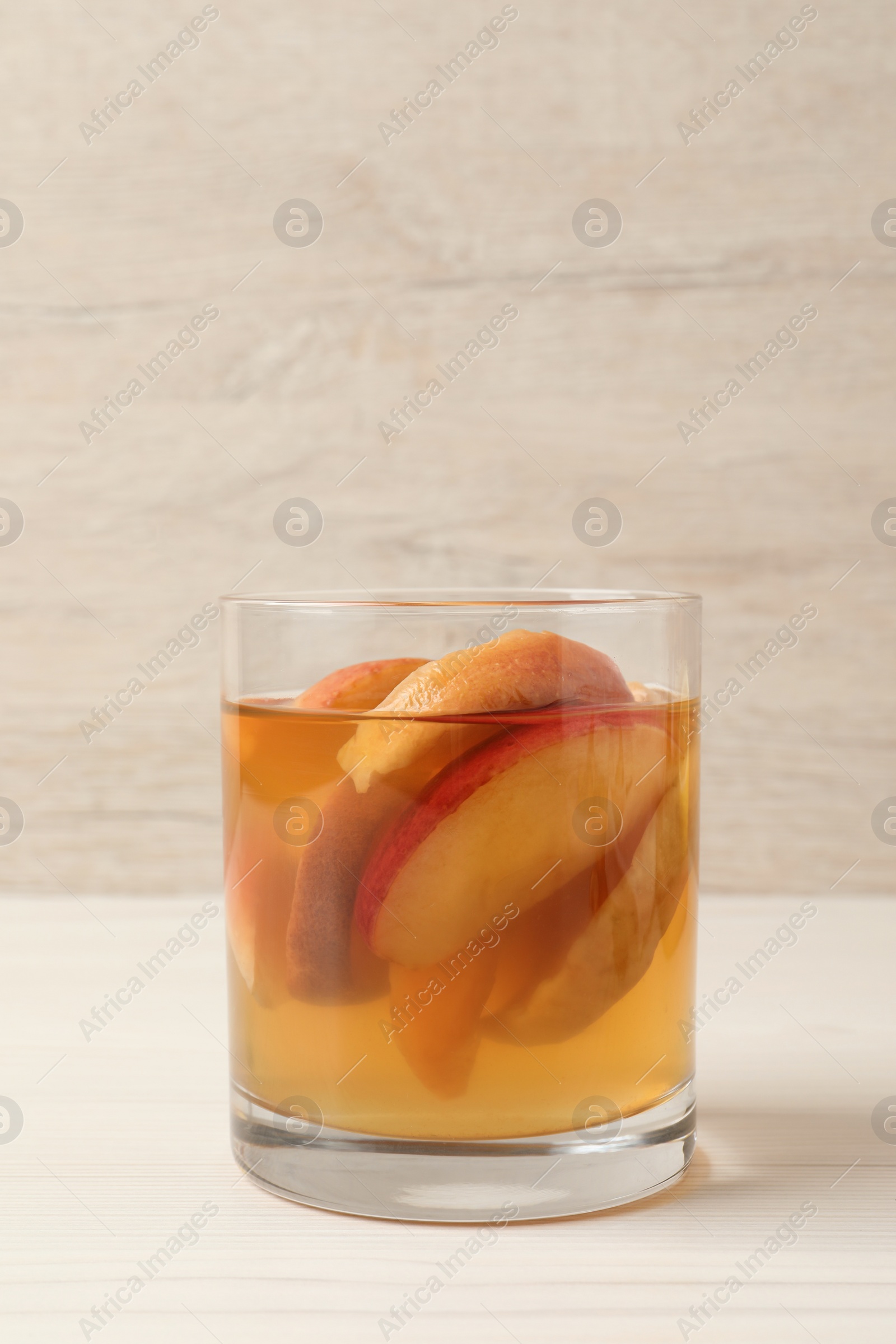 Photo of Delicious compot with dried apple slices on light wooden table