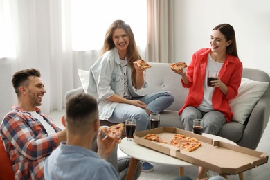 Photo of Group of friends eating tasty pizza at home