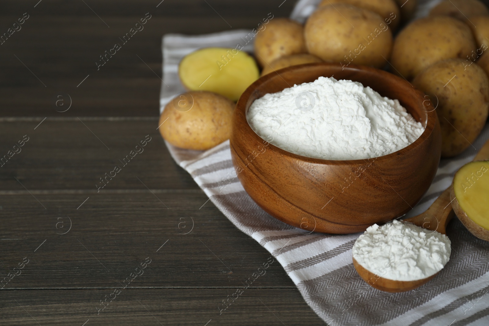 Photo of Starch and fresh raw potatoes on wooden table. Space for text