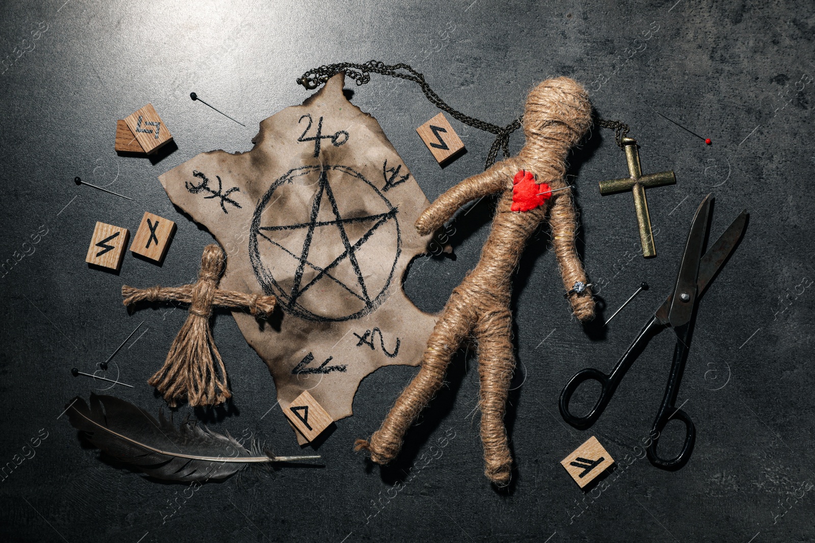 Photo of Voodoo dolls and ceremonial items on grey table, flat lay