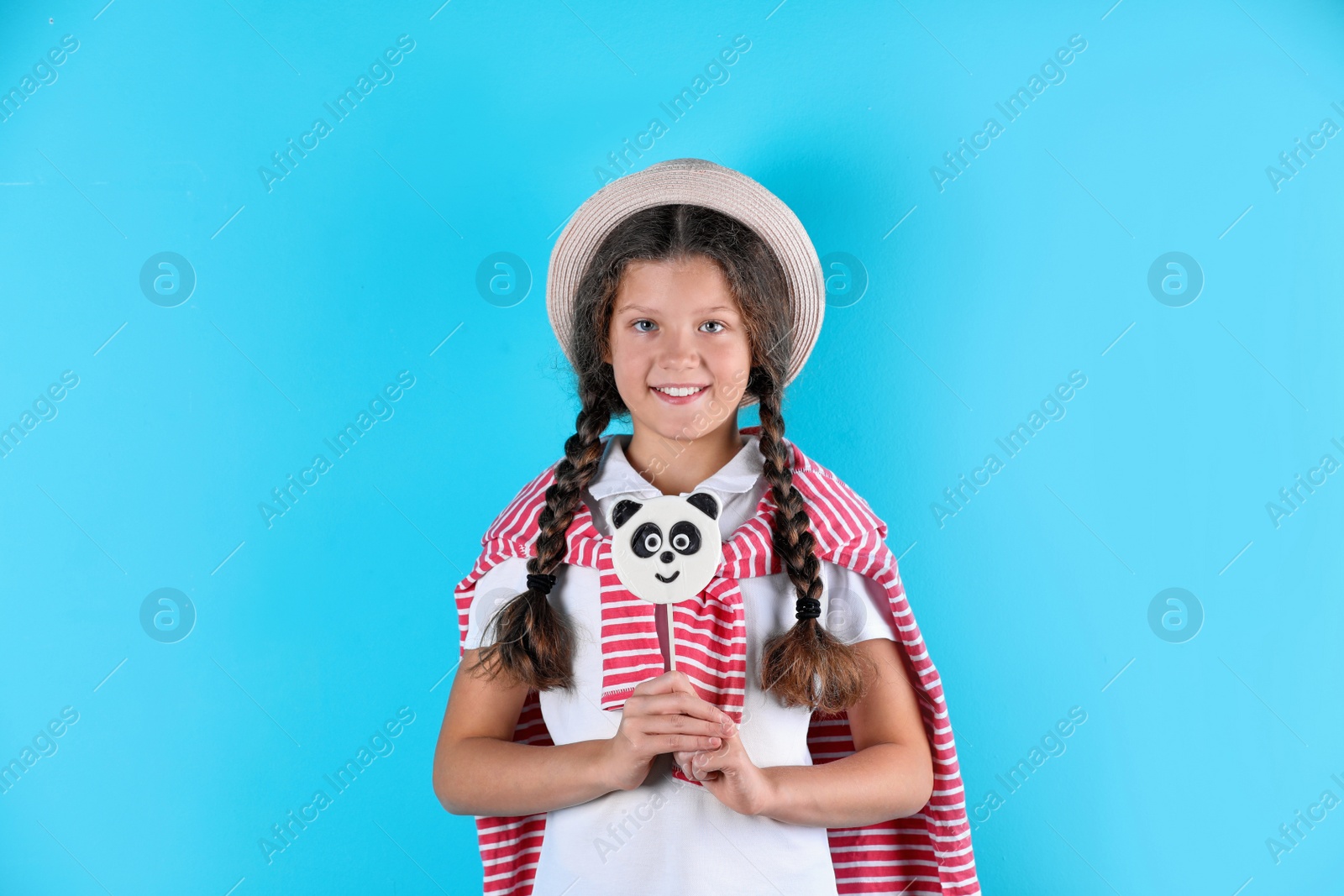 Photo of Little girl with candy on color background