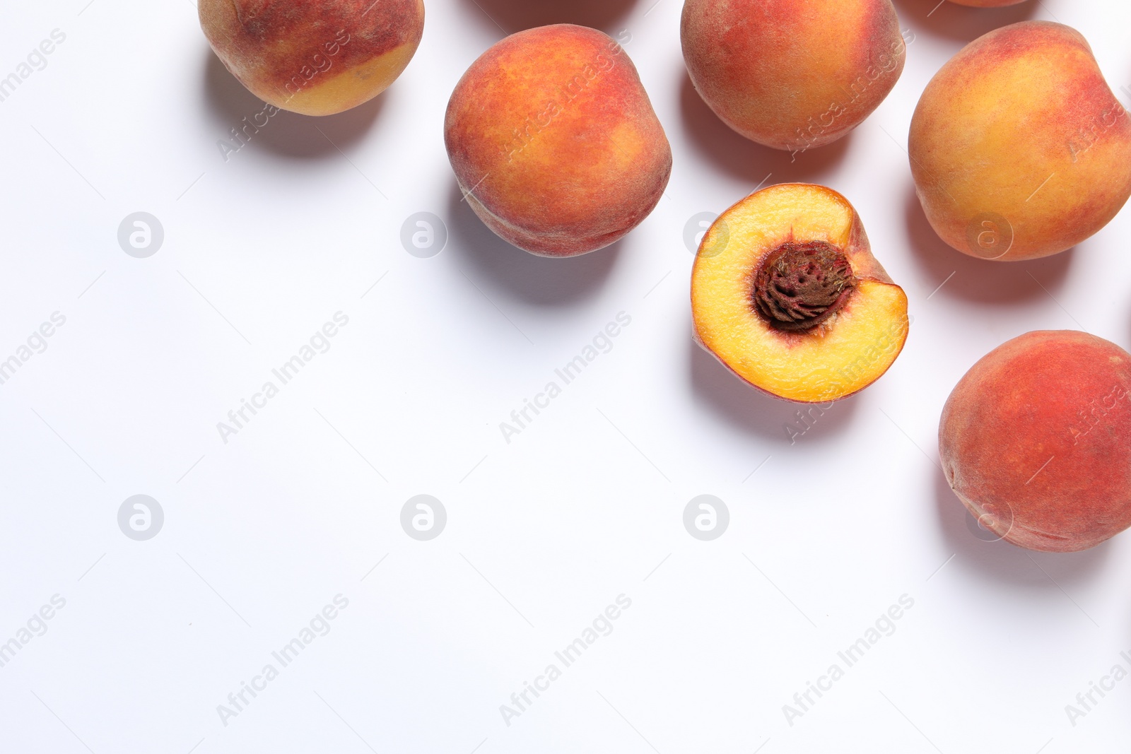 Photo of Cut and whole fresh ripe peaches on white background, flat lay. Space for text