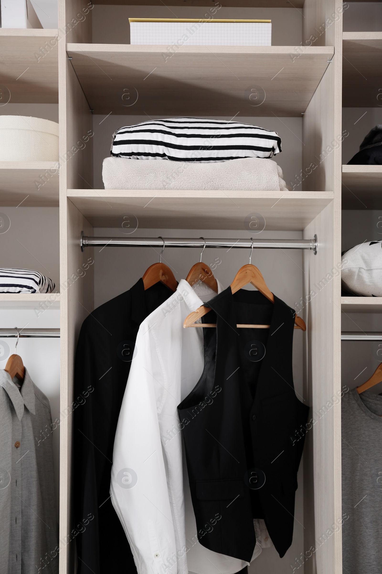 Photo of Stylish clothes and home stuff in large wardrobe closet