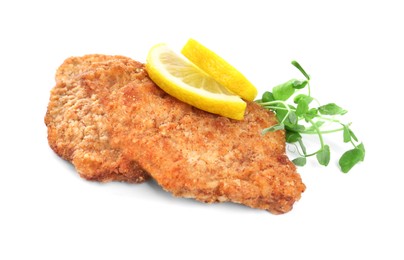 Delicious schnitzels with lemon and microgreens on white background