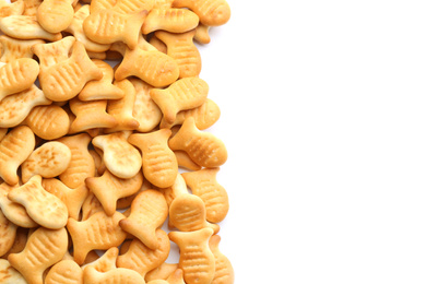 Delicious crispy goldfish crackers on white background, top view