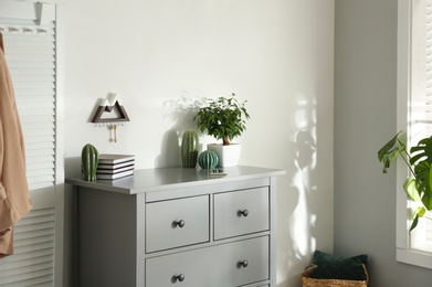 Grey chest of drawers in stylish room interior