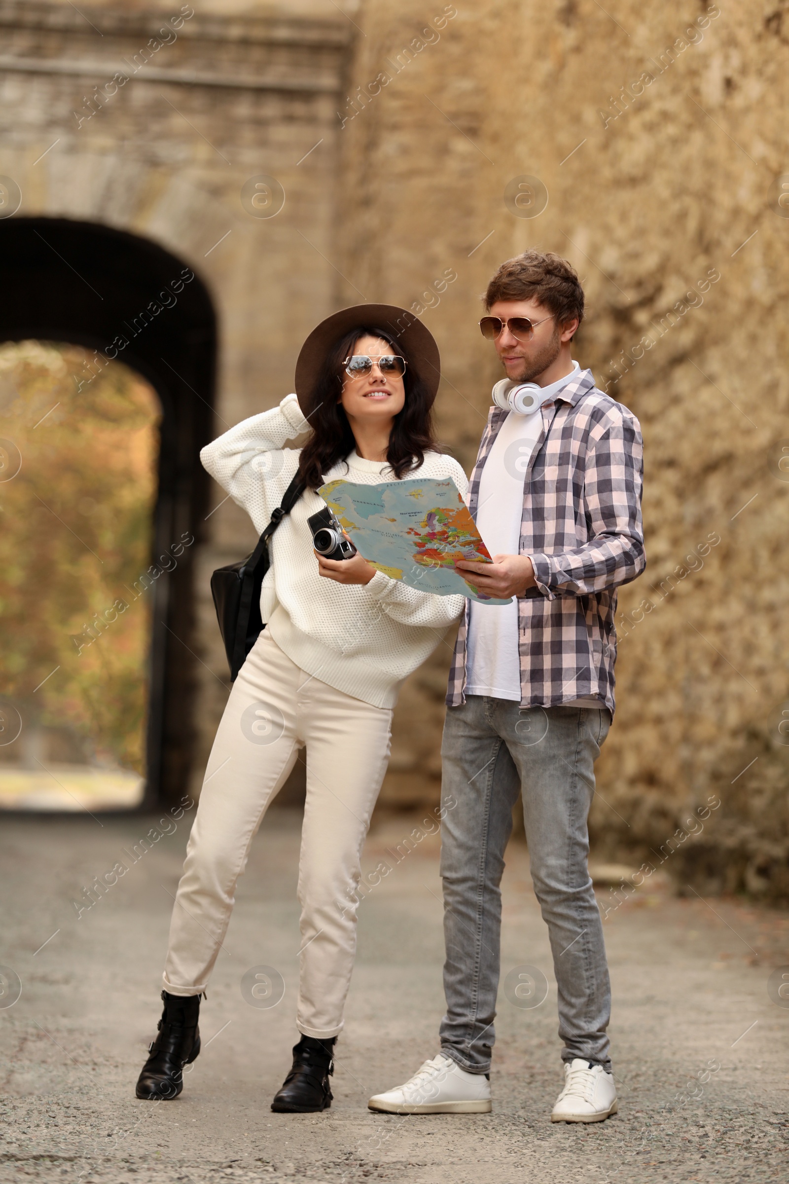 Photo of Couple of travelers with map and camera on city street