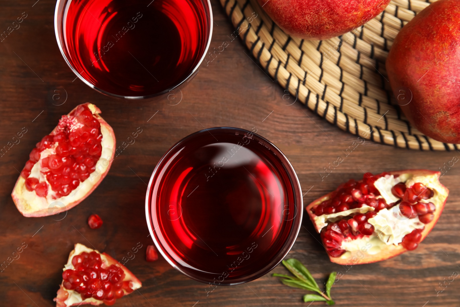 Photo of Pomegranate juice and fresh fruits on wooden table, flat lay