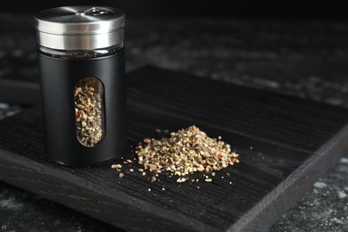 Photo of Stylish shaker with pepper on dark table, closeup