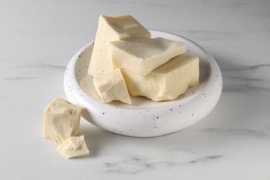 Photo of Pieces of tasty white chocolate on marble table