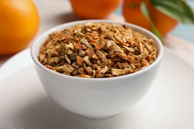 Photo of Bowl of dried orange zest seasoning and fresh fruits on plate