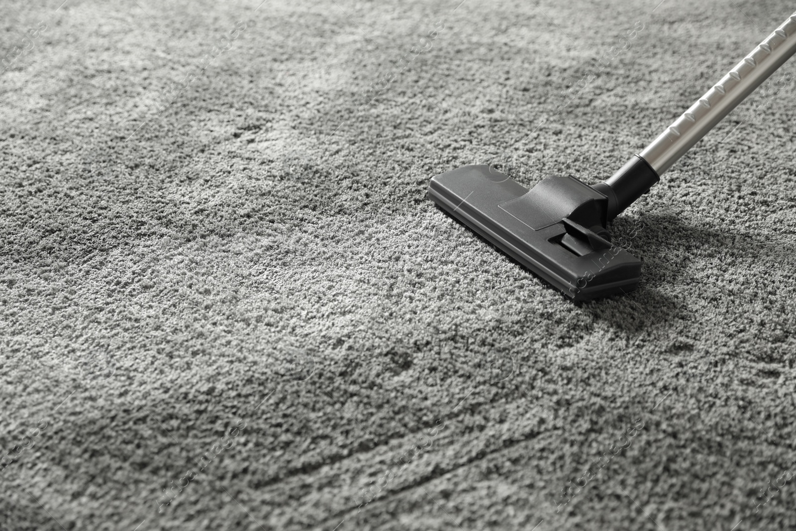 Photo of Removing dirt from grey carpet with vacuum cleaner. Space for text