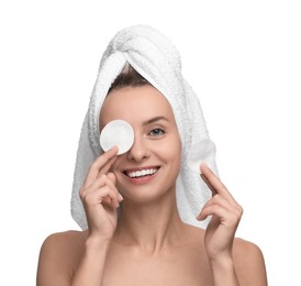 Smiling woman removing makeup with cotton pads on white background