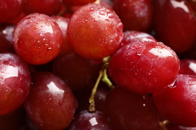 Photo of Bunch of red fresh ripe juicy grapes as background, closeup