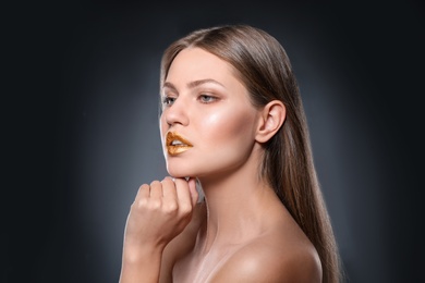 Portrait of beautiful lady with gold lipstick on grey background