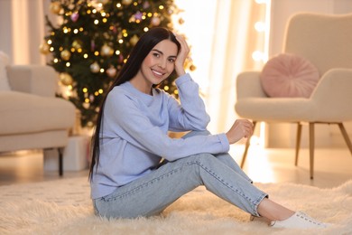 Photo of Beautiful young woman in room decorated for Christmas