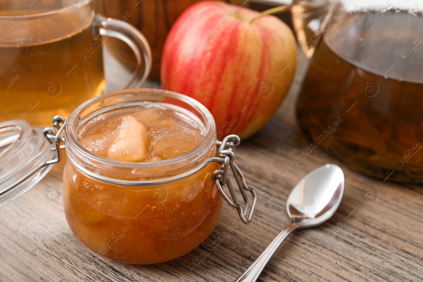 Photo of Delicious apple jam in jar on wooden table