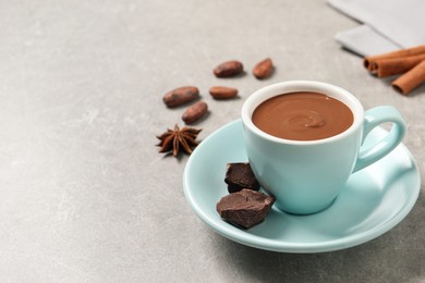 Photo of Yummy hot chocolate in cup on light grey table. Space for text