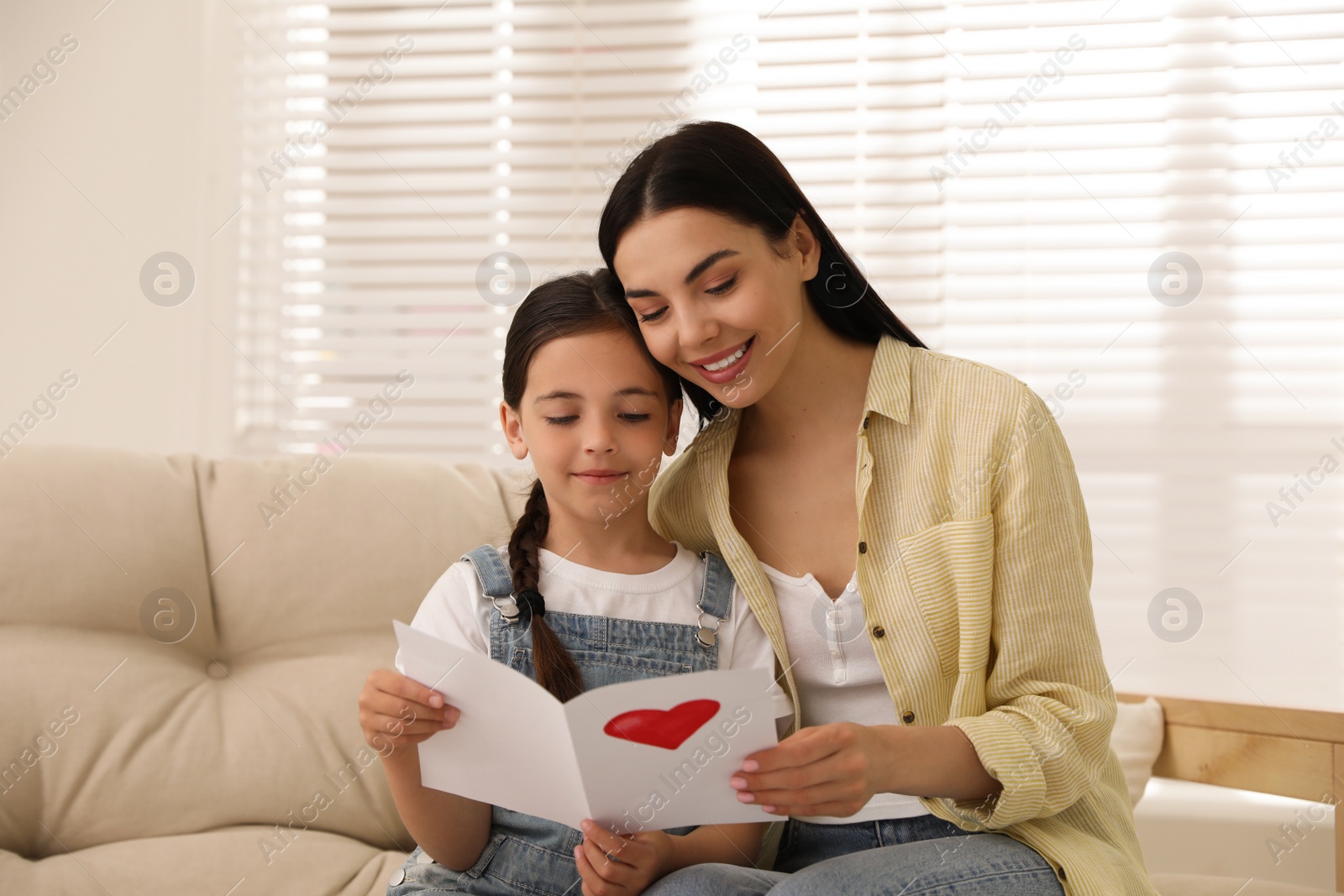 Photo of Little daughter congratulating her mom at home. Happy Mother's Day