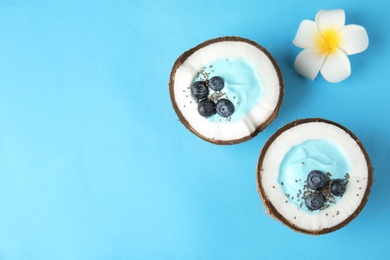 Coconuts with yummy spirulina smoothie on color background, top view. Space for text