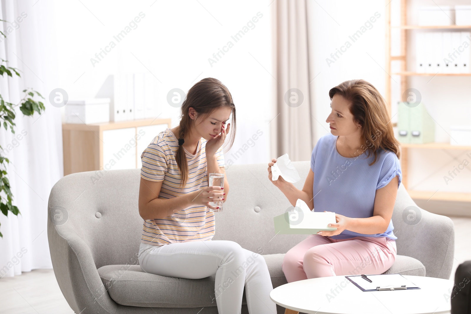 Photo of Psychotherapist working with teenage girl in office