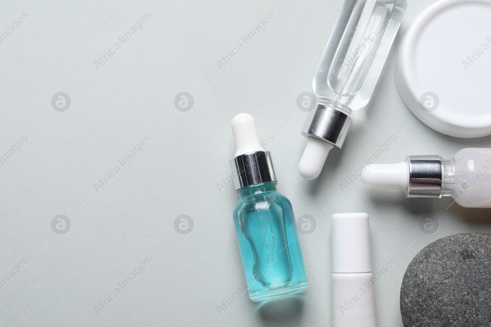 Photo of Flat lay composition with cosmetic serum on light grey background. Space for text