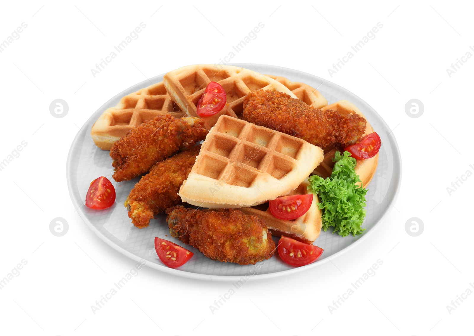 Photo of Plate with tasty Belgian waffles, fried chicken, tomatoes and lettuce isolated on white