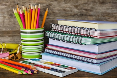 Different school stationery on table against wooden background