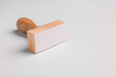 Photo of One wooden stamp tool on light grey background, closeup. Space for text