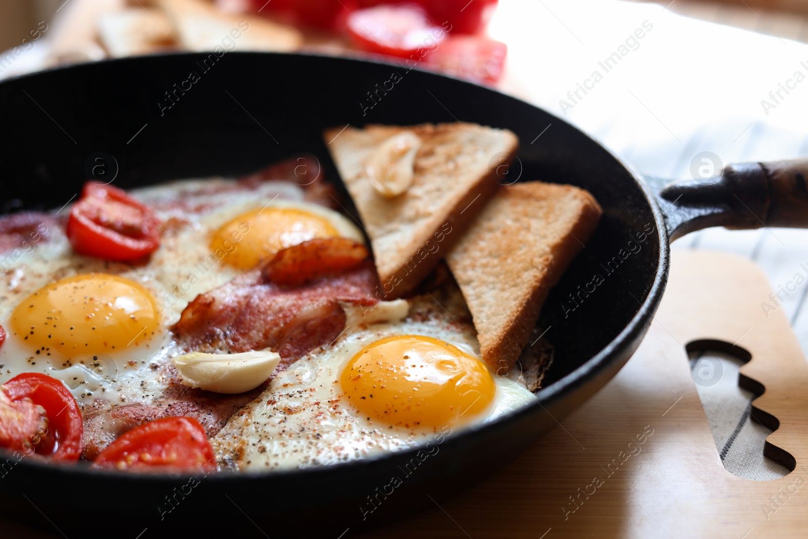 Photo of Delicious fried eggs with bacon and tomatoes in pan, closeup