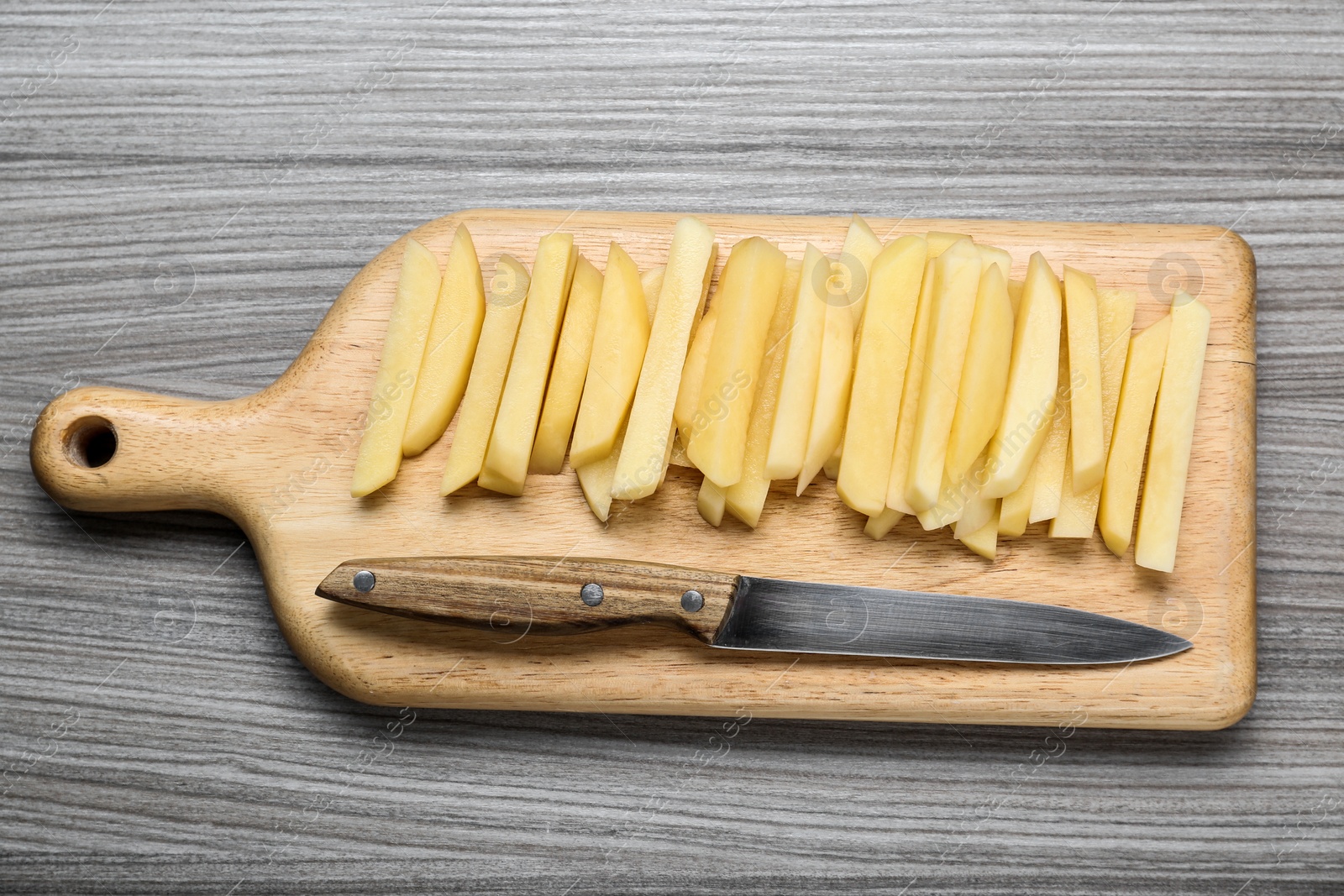 Photo of Cut raw potatoes on wooden table, top view