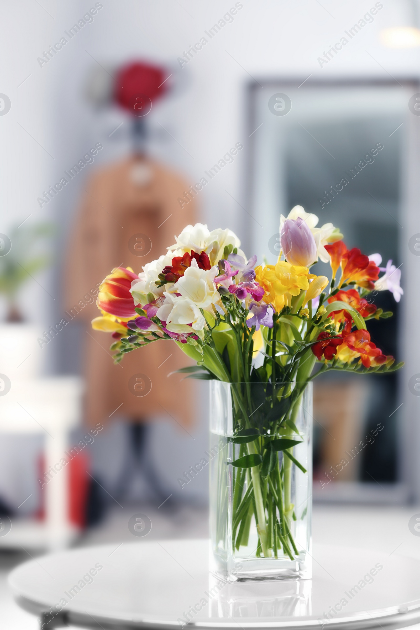 Photo of Beautiful bouquet of freesia flowers indoors