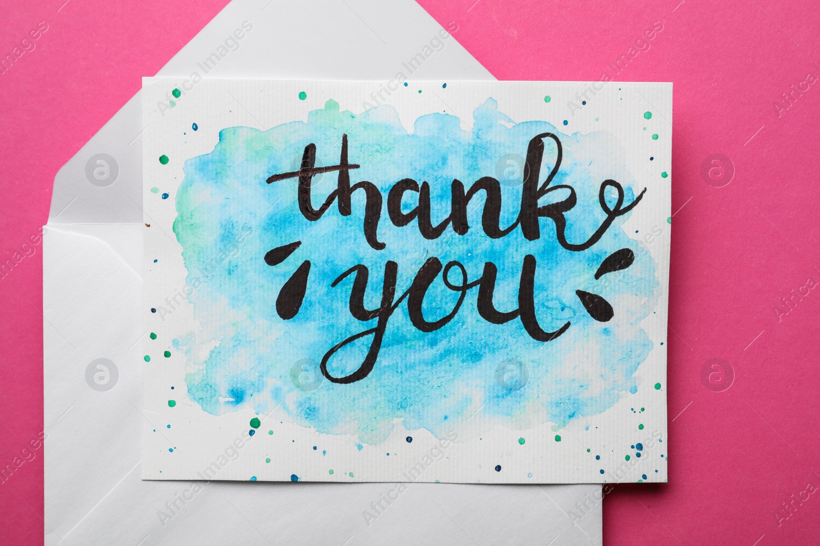 Photo of Envelope and card with phrase Thank You on pink background, top view