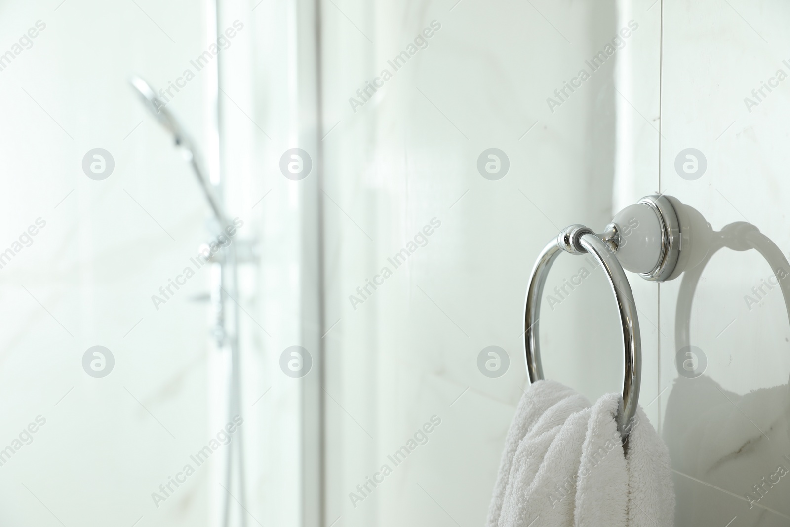 Photo of Holder with clean towel on light wall in bathroom. Space for text