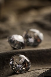 Photo of Three beautiful gemstones for jewelry on stone surface, closeup. Space for text