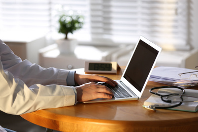 Professional doctor working on laptop in office, closeup