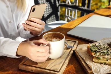 Photo of Food blogger taking photo of her lunch at cafe, closeup