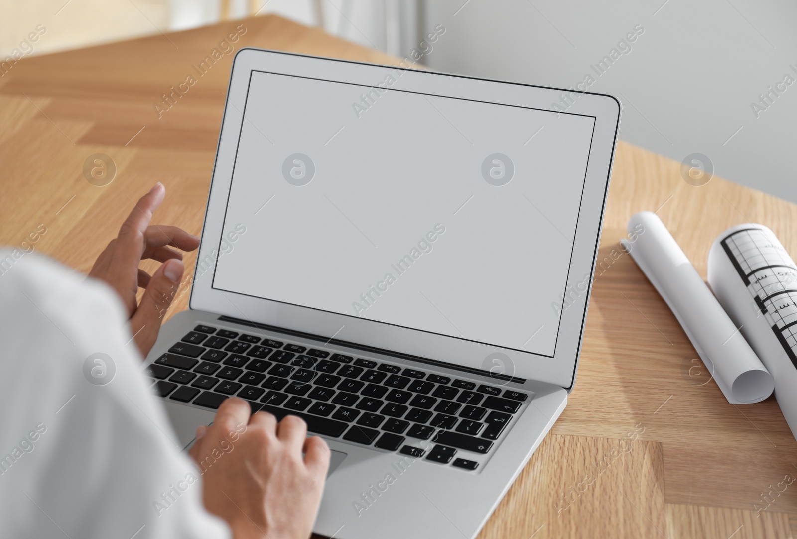 Photo of Woman using video conference to communicate with her coworkers at wooden table, closeup