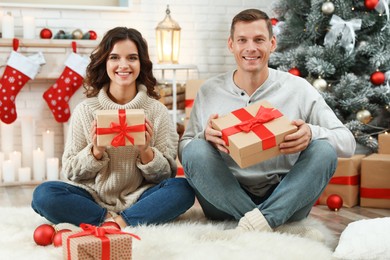 Image of Happy couple with Christmas gifts at home