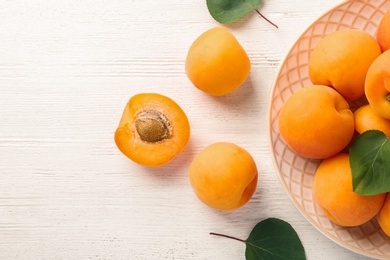 Composition with delicious ripe apricots on white wooden background, top view. Space for text