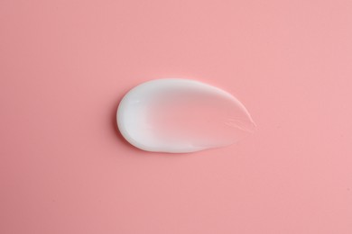 Photo of Sample facial cream on pink background, top view