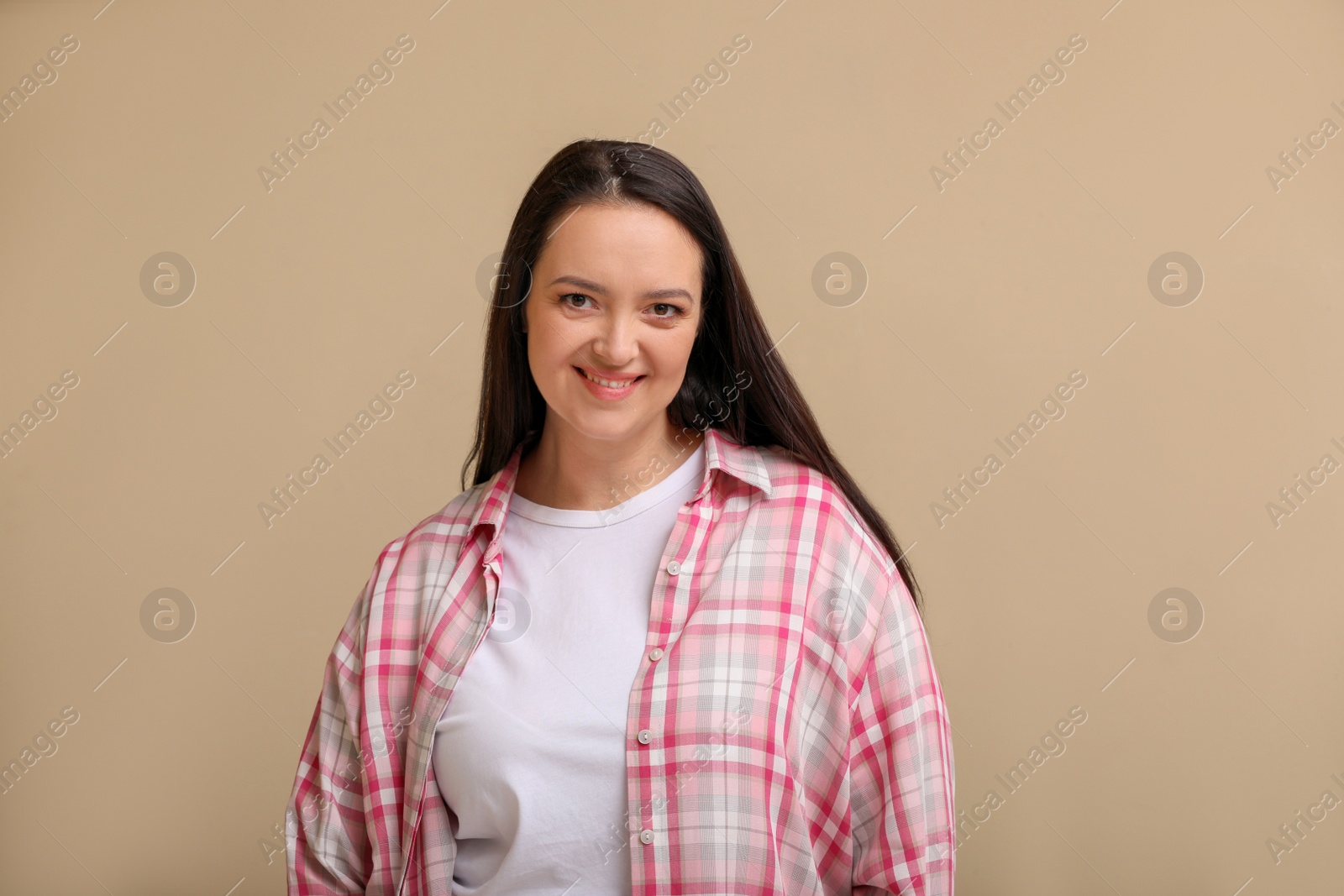 Photo of Beautiful overweight woman with charming smile on beige background