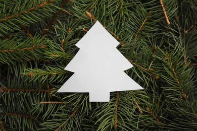 Christmas tree cut out of paper on branches, top view