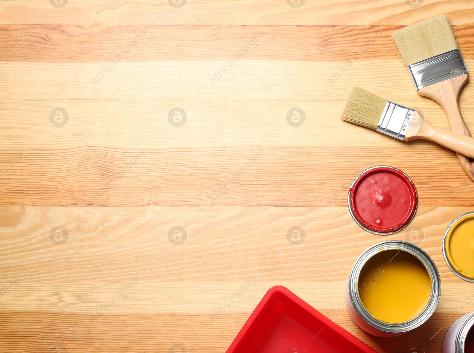 Photo of Flat lay composition with paint cans and brushes on wooden background. Space for text