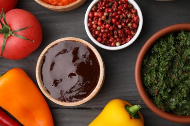 Photo of Different fresh marinades in bowls and ingredients on grey wooden table, flat lay