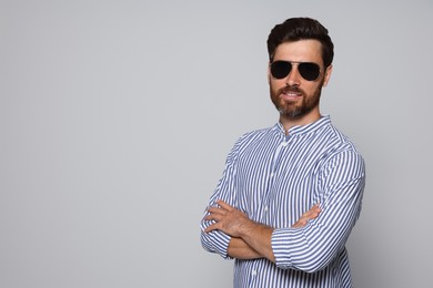Photo of Portrait of bearded man with sunglasses on grey background. Space for text