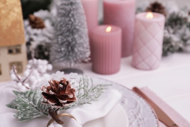 Photo of Festive place setting with beautiful dishware and cone for Christmas dinner on white wooden table, closeup. Space for text