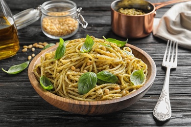 Photo of Plate of delicious basil pesto pasta served for dinner on table