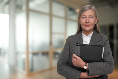 Lawyer, consultant, business owner. Confident woman with file folders indoors, space for text